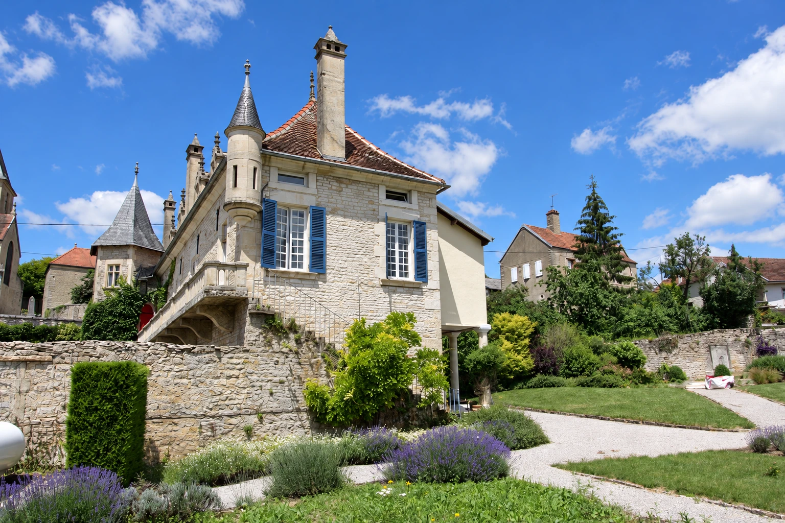 La tour et la façade en pierre du Prieuré, vues depuis les jardins