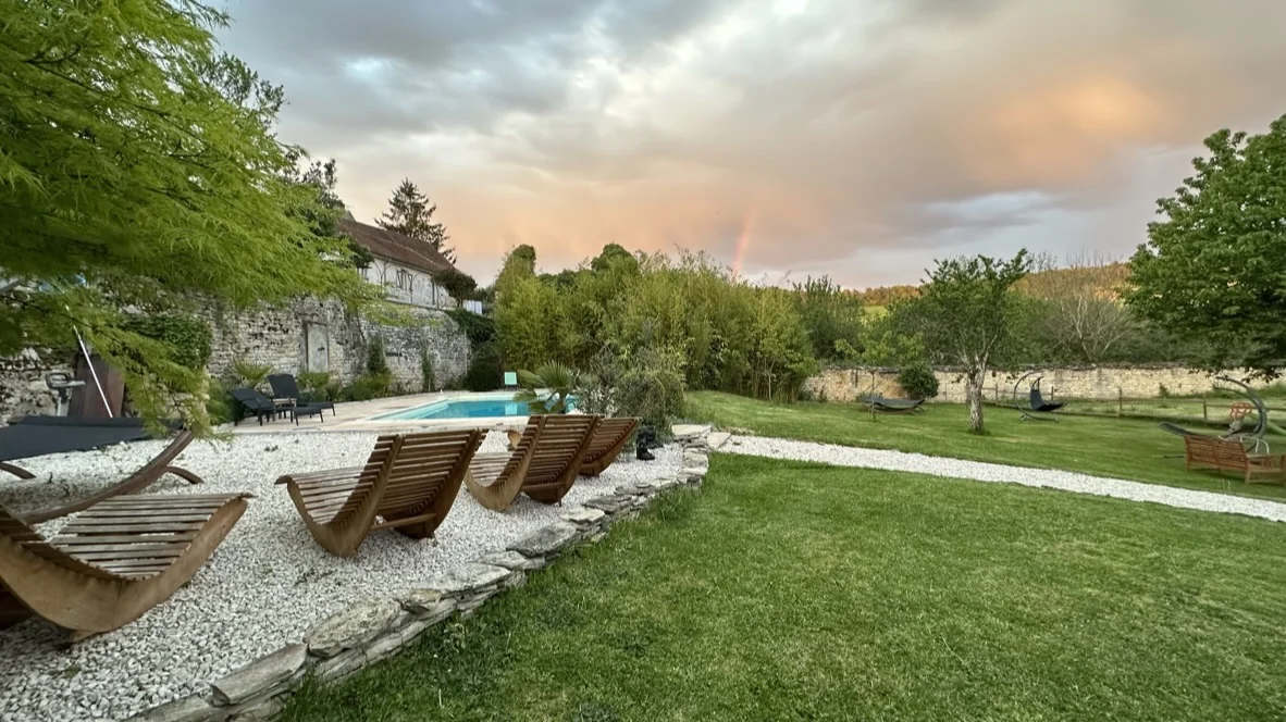 La piscine, les transats et le parc sous le ciel du soir