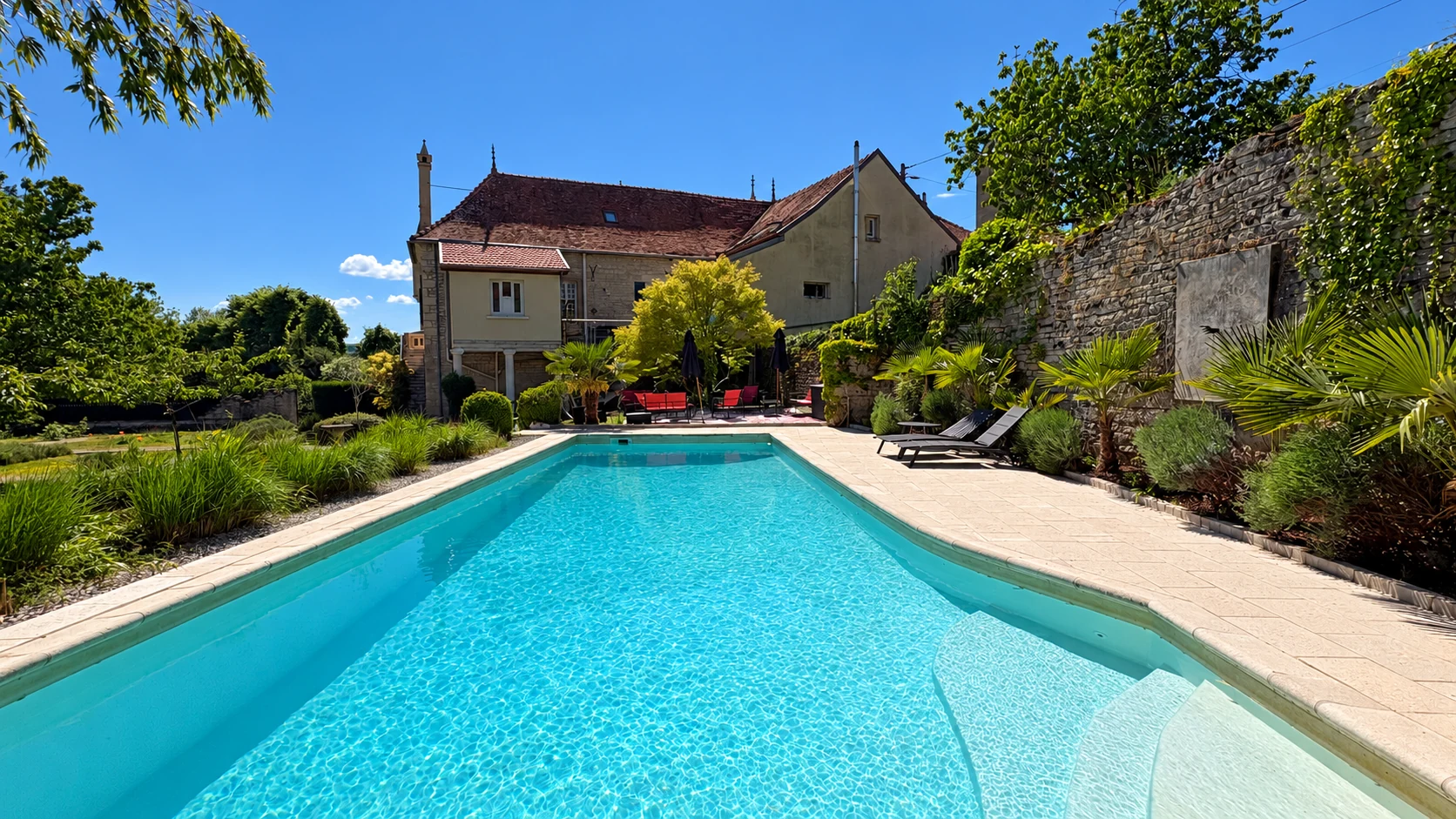 La piscine extérieure et ses transats