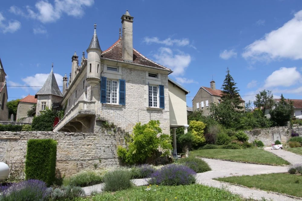 La tour et la façade en pierre du Prieuré, vues depuis les jardins